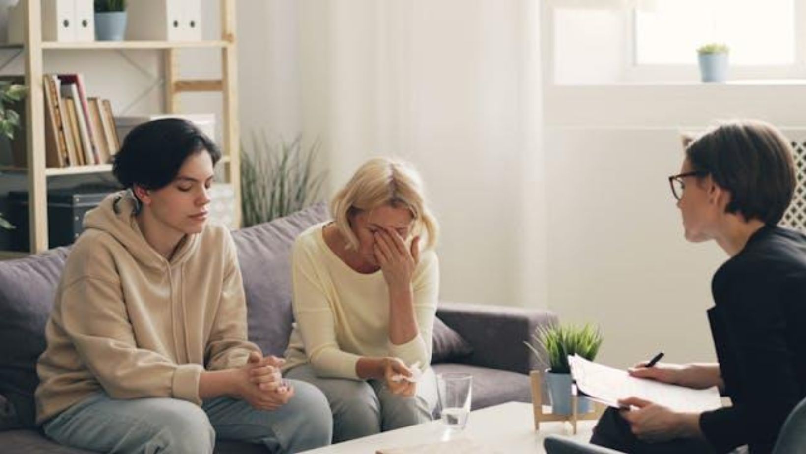 Mother and her son sitting in front of a therapist 