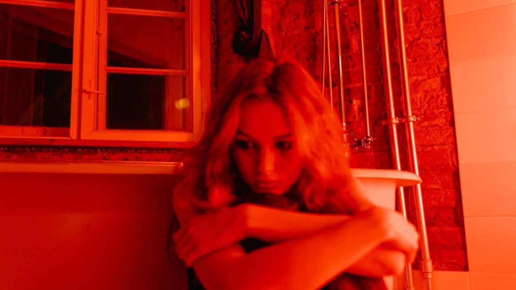 Woman sitting next to a bathtub